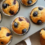 Cottage cheese blueberry muffins in muffin tin with golden tops