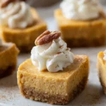 A tray of Healthy Pumpkin Cheesecake Bites with whipped cream and pecans.